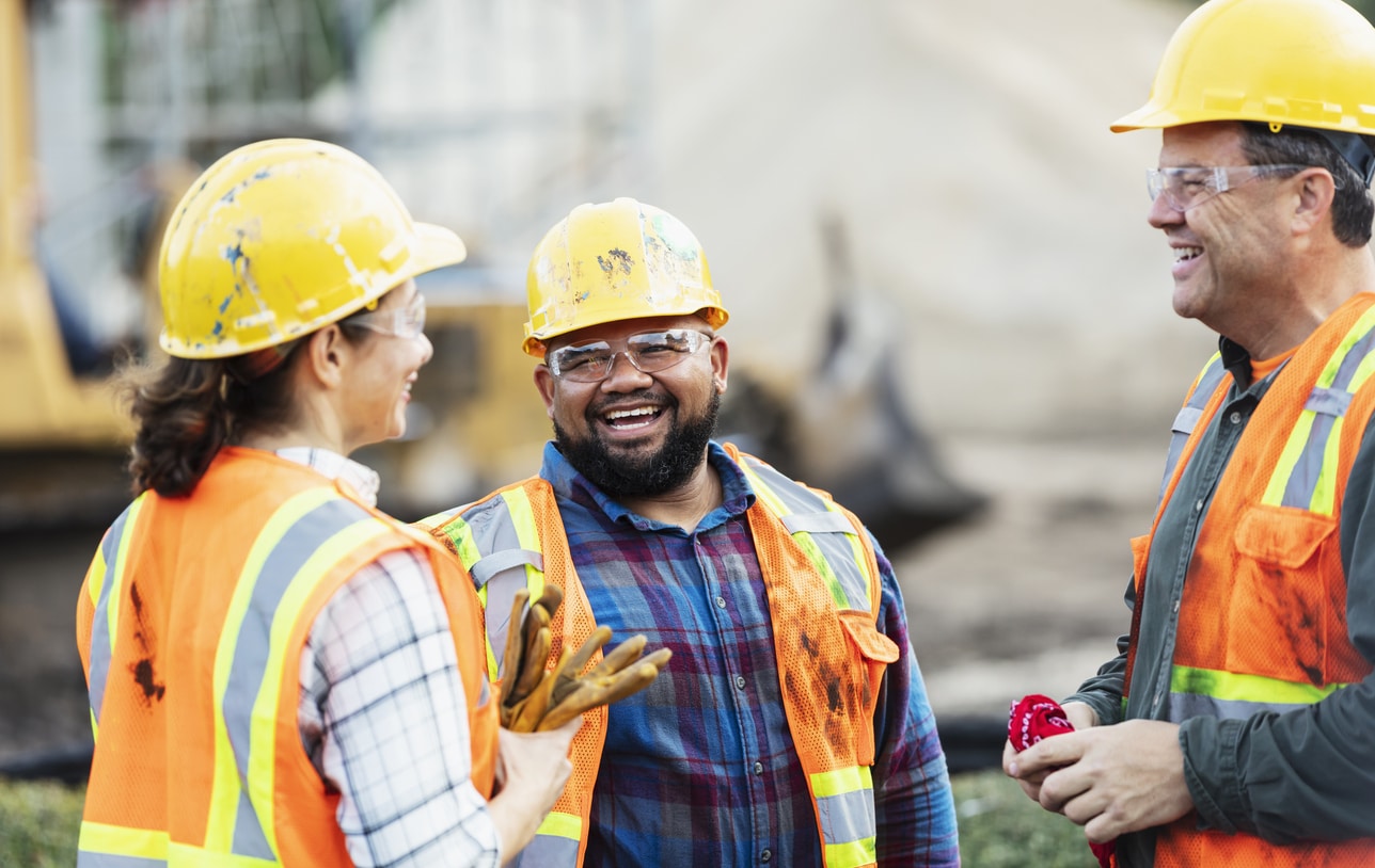 A group of workers at a construction site wearing hard hats